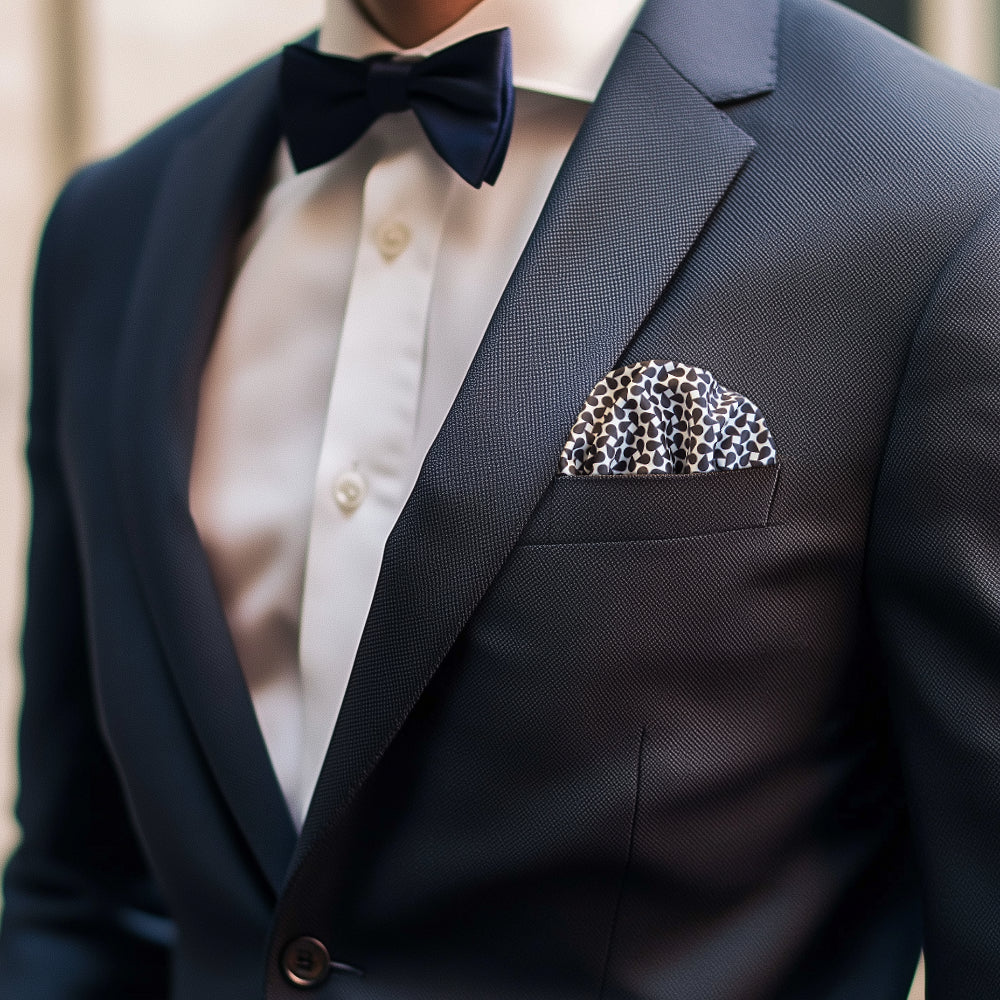 Dark blue suit with white tie, blue bow tie and Keffiyeh pattern pocket square