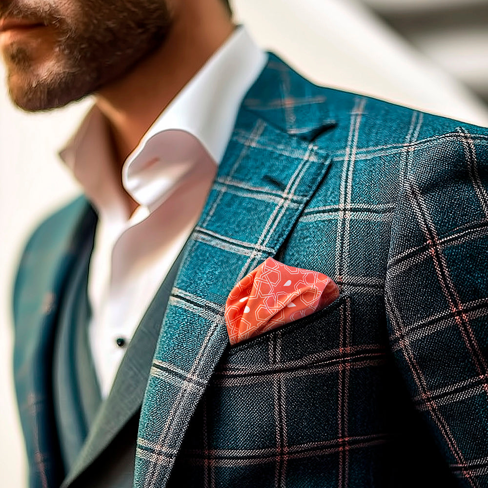 Man wearing a teal checkered suit with a orange pocket square, blurred background