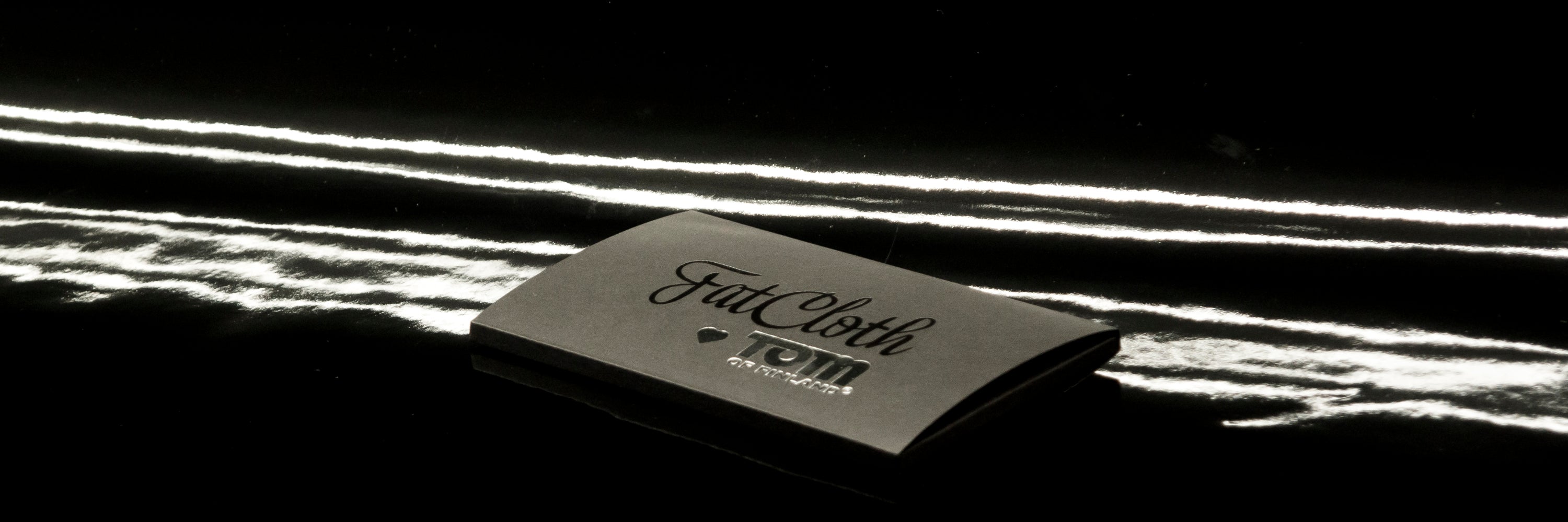 Black FatCloth product box on black latex background