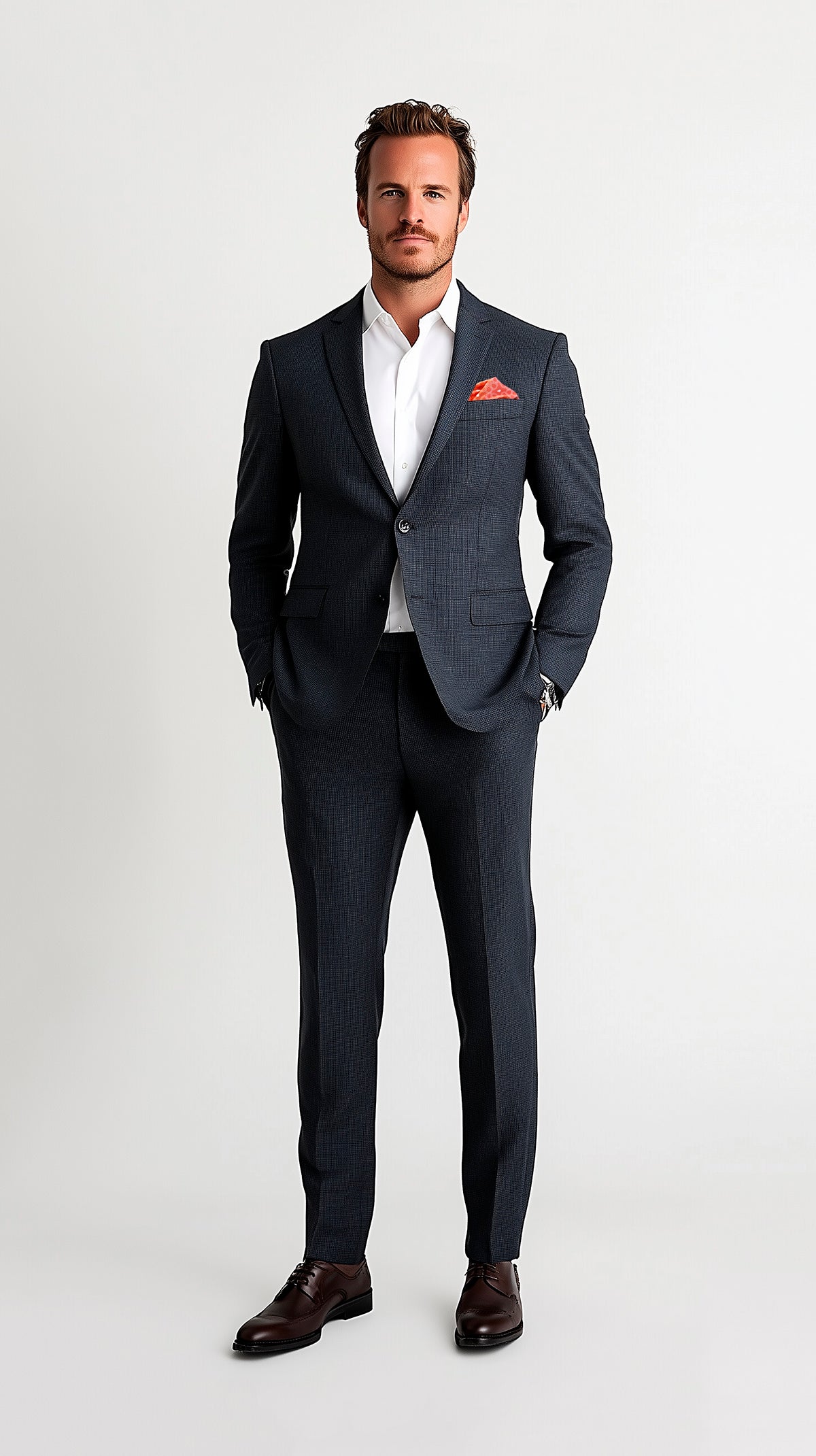 Man in dark modern fit suit wearing an orange pocket square puff fold