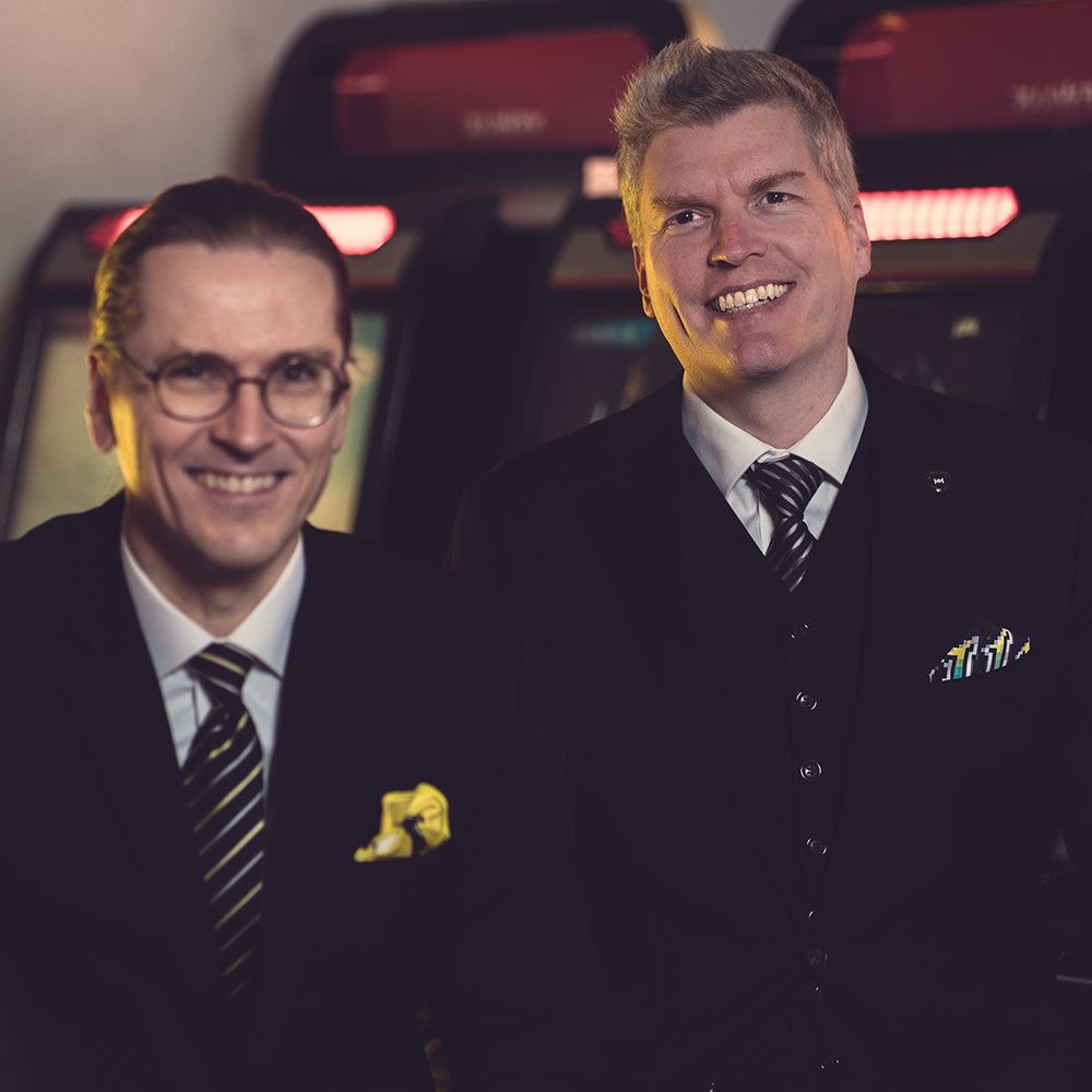 Gentlemen having a well deserved laugh wearing matching Herrasmieshakkerit x FatCloth pocket squares